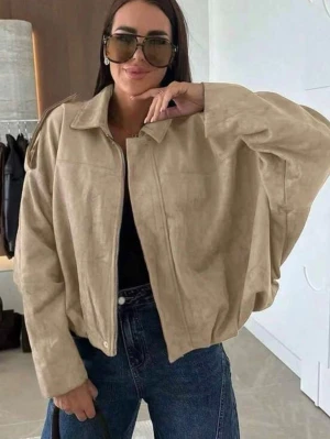 Beige oversized mockajacka - Snygg beige oversized jacka i mockaimitation med dragkedja framtill och klassisk krage. Jackan har långa ärmar och en avslappnad passform som ger en cool och trendig look. Perfekt att slänga över en t-shirt och jeans.