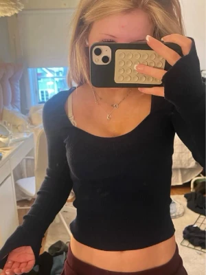Mörkblå ribbad tröja Gina Tricot - Snygg mörkblå långärmad tröja från Gina Tricot med ribbad struktur och djup rundad urringning. Tröjan är figurnära och har långa ärmar med tumhål. Perfekt att matcha med jeans eller kjol för en trendig look.