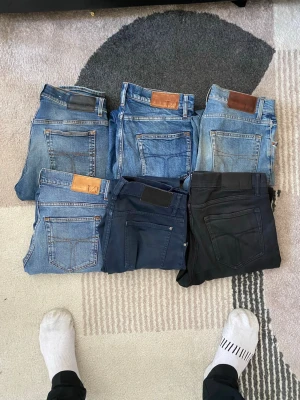 Mix av jeans i olika färger - Säljer ett gäng snygga jeans i olika blå och svarta nyanser, flera med läderpatch bak. Klassisk femficksmodell, raka ben och tillverkade i Italien. Perfekta för dig som gillar stilrena och tidlösa jeans. Märke: Tiger of sweden 