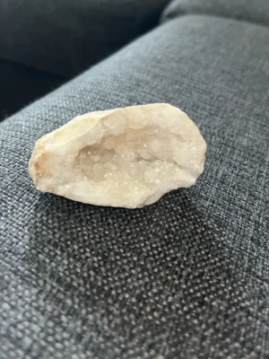 Liten naturlig kvartsgeod med glittrande kristaller - Vacker liten kvartsgeod med skimrande kristaller inuti. Naturligt formad med vit/mjölkig kvarts och fint glittrande drusy-kristaller i hålrummet. Perfekt som dekorationssten, samlarobjekt eller till dig som gillar kristaller och mineraler. 