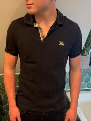 Svart pikétröja från Burberry - Svart pikétröja från Burberry. Bra skick, storlek S/M! Självklart äkta 