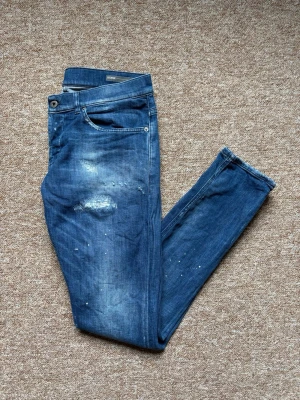 Blåa dondup jeans med slitningar - Sjukt snygga dondup george jeans med feta slitningar och sjuuukt fet tvätt, jättebra skick också även fast de är köpte begagnade(typ nya) säljer för dunderpris då jag sparar upp till körkort
