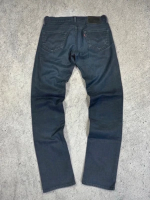 Mörkblå raka jeans från Levi's - * Midjebredd – 39,5 cm * Grenhöjd (fram) – 23 cm * Lårbredd – 29 cm * Total längd – 103 cm * Benöppning (nederkant) – 17 cm