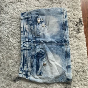 Lowwaist mini jeanskjol med glittriga detaljer - Snygg low waist mini jeanskjol i strl 27, midja:38. Kommer fler unika jeansshorts o kjolar så följ!! Obs!! Knappen har gått av därav priset💓