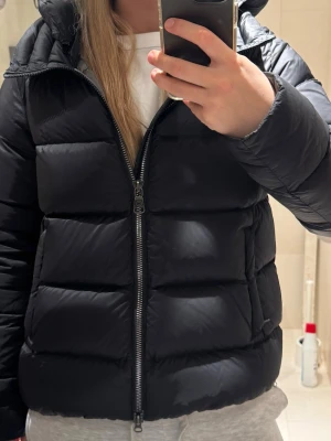 Svart pufferjacka med huva - Nypris: 6 999kr på SkiStar. Säljer min svarta glansiga pufferjacka från Colmar med huva och tydlig logga på ärmen. Jackan har inga defekter och är vadderad för extra värme. Perfekt för kalla dagar och har en clean, glansig look som passar till allt. Säljer den pga för lite användning. Köptes januari 2025 på SkiStar.