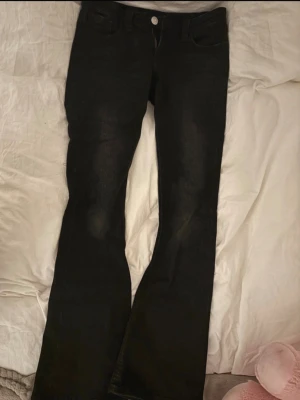 Svarta bootcut jeans - Svarta bootcut jeans från Gina Tricot med klassisk femficksdesign och snygga nitar på bakfickan. Jeansen har dragkedjegylf, bälteshällor och är tillverkade i stretchigt denim för en tight passform.  M 14+!!!