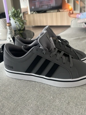 Grå sneakers från Adidas - Gråa sneakers från adidas,helt nya med pris lapp aldrig använda 