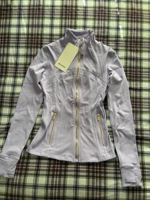 Lululemon luon define jacket i Roland violet - Lululemon Roland violet luon Define Jacket with Gold Hardware 💜✨ The most gorgeous sage/matcha green shade paired with stunning gold zippers! This is the super soft Nulu fabric version. It’s in perfect condition/like new and provides that iconic snatched silhouette. Such a "mint moment" for your gym or hot girl walk outfits!  * Brand: Lululemon * Size: 2 & 4 (xxs & xs) * Color: purple * Condition: worn once Feel free to message me with any questions 💌  #lululemon #athleisure #pilatesaesth