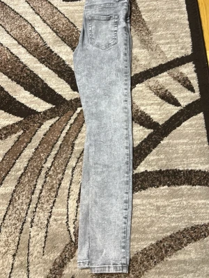 Grå skinny jeans med acid wash - Säljer ett par grå Jens med snygg acid wash-effekt. Jeansen har klassisk femficksdesign och smal passform hela vägen ner. Perfekta för dig som gillar en trendig och avslappnad stil.