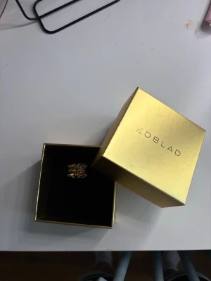 Guldfärgad ring från Edblad - Säljer en snygg guldfärgad ring från Edblad med geometriskt mönster av små pyramidformade detaljer. Ringen har en modern och unik design som verkligen sticker ut. Perfekt accessoar för dig som gillar statement-smycken.