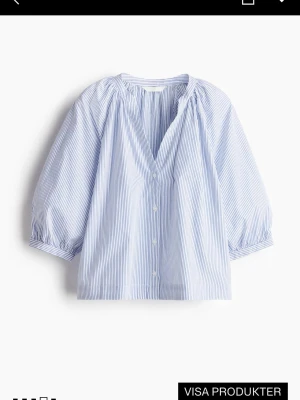 Blårandig blus med trekvartsärm - Luftig blus med tunna blå och vita ränder, v-ringning och knäppning framtill. Blusen har trekvartsärmar med lätt puff och resår vid ärmslut. Perfekt till jeans eller shorts för en fräsch look. Tillverkad i mjukt bomullstyg. Slutsåld i storlek xs