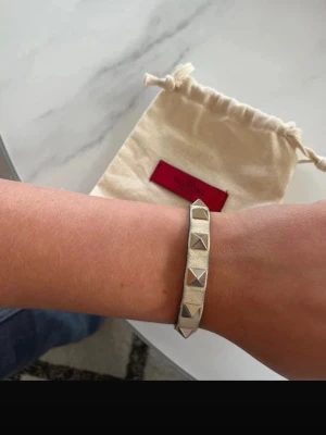 Vitt ÄKTA valentino nit armband  - Valentino ÄKTA nit armband. Beige/vitt med guld nitar. Slitet men fint. Går att limma ihop (se sista bilden)nypris:3000kr
