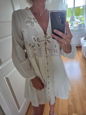 Vit kortklänning med broderade blommor - Söt vit klänning från Zara. Använd en gång, därför som ny. Storlek L, men passar mig som är S-M.