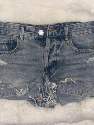 Blå slitna jeansshorts med fransar - Säljer ett par blå denimshorts från Pull & Bear! Midjan är ungefär 38 cm, de är midwaist💕💕💕