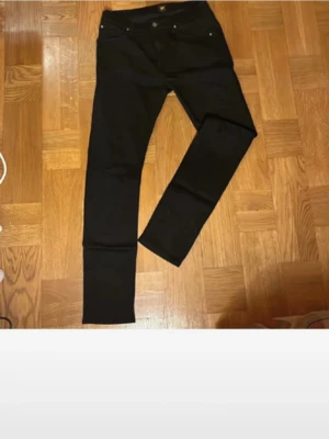 Svarta skinny jeans - Säljer ett par svarta skinny jeans med klassisk femficksdesign och normal midja. Jeansen har smal passform och raka ben. Perfekta till en streetwear-look eller att matcha med en hoodie. Materialet är troligtvis bomull med stretch.