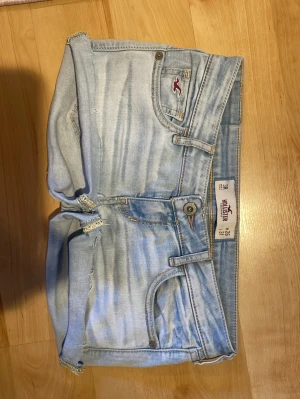 Lågmidjade jeansshorts från Hollister - Avklippta från jeans till shorts. Låg midja, fint skick! En liten defekt är att lappen med märket sitter löst se bild 4😊 Observera att de är klippta. Har vikt upp de på bilden då jag tycker det är mycket snyggare. En aning för små på mig. MIDJEMÅTT: 37 cm. Ganska stretchigt material 