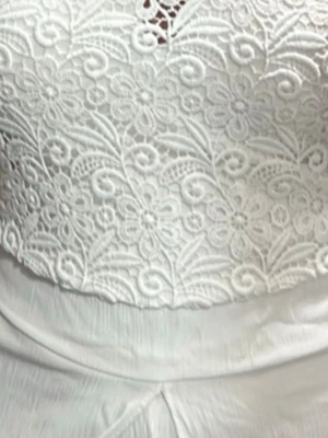 Vit spetsig ärmlös topp - Superfin vit topp med blommig spets och hög hals. Toppen är ärmlös och har en elegant, feminin look med detaljerat spetsmönster över hela framsidan. Perfekt för dig som gillar romantisk stil och vill sticka ut lite extra.