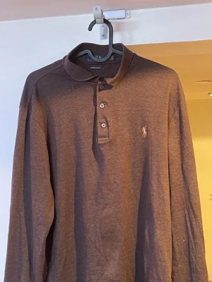 Ralph Lauren långärmad piké - En flitigt använd brun Ralph Lauren piké i storlek M