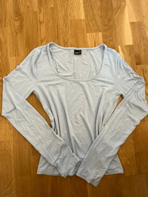 Ljusblå långärmad topp Gina Tricot Storlek M (passar även S) - Ljusblå långärmad topp från Gina Tricot med rund, djup ringning. Armarna har en slits där nere. Endast använd några gånger! Storlek M men passar även mig som har S
