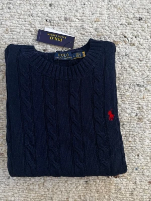 Marinblå Ralph Lauren Sweater - Marinblå Sweater från Polo Ralph Lauren, har QR-kod. Kommer med prislapp och zipbag. 🚨PASSFORM: M, 13-16 år, 165-180 cm🚨