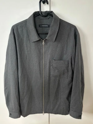 J.lindeberg overshirt herr M  - Grå ursnygg populär och elegant Overshirt från J.lindeberg i storlek M säljes. I princip helt ny i nyskick! Grym passform perfekt nu till sommaren och tveka inte vid minsta fråga eller fundering.