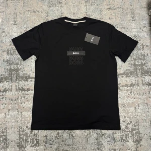 Svart t-shirt med tryck - Svart t-shirt med stilrent tryck av loggan i flera lager på bröstet. Klassisk rund hals och korta ärmar. Tillverkad i mjuk bomull som känns skön mot huden. Perfekt för en clean och modern look.