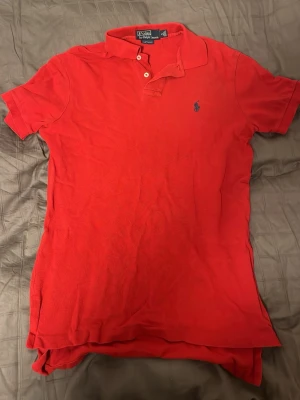 Ralph Lauren Piké  - Tja säljer nu en röd Ralph Lauren Piké i storlek S. Inga tydliga defekter. Hör av dig vid frågor eller funderingar