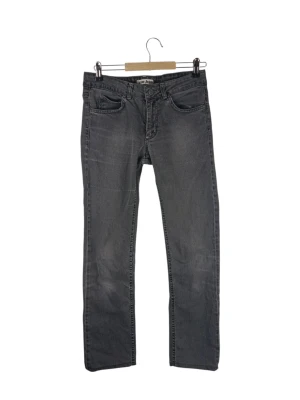 Acne Jeans Hex Discash gråa jeans, storlek 27/32 - Ett par gråa jeans från Acne Jeans. Jeansen har en klassisk design med raka ben och fem fickor. Gylfen stängs med dragkedja och knapp. De har en läderlapp med logotyp baktill i midjan. Midja: 36cm Långt: 66cm