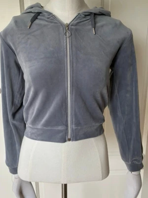 Grå velour hoodie med dragkedja - Mjuk och skön hoodie i grå velour med dragkedja framtill och huva med snören. Croppad modell med långa ärmar. Säljs tillsammans med likadana byxor till. Säljer pga att de inte passar💓