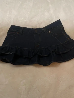  Jeanskjol med volang - Snygg mörkblå jeanskjol med volanger. 💗Midjemått:32cm