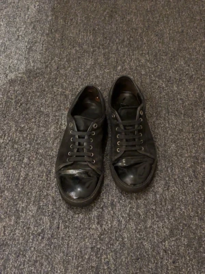 Svarta låga sneakers från Lanvin - Feta lanvins i svart mocha och glansig tå. Skorna är i storlek uk 9 vilket motsvara storlek 43. De är i hyfsat bra kvalité men lite smutsiga vilket är väldigt enkelt att fixa.                    Priset är ej hugget i sten 🪨.                                                     Hör av dig vid minsta lilla fundering‼️‼️                            Mvh 