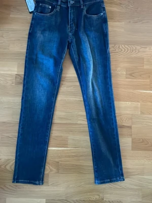 Raka Mörkblå Dolce Gabbana Jeans - Snygga mörkblå jeans med raka ben och tvättade detaljer framtill. Klassisk femficksmodell med knapp och dragkedja. Jeansen är gjorda i denim och har en stilren look som passar till det mesta. Perfekta för dig som gillar en enkel men trendig stil.