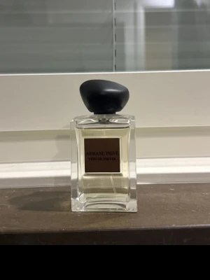 Armani Privé Vetiver D'Hiver parfym - Exklusiv parfym från Armani Privé, Vetiver D'Hiver. Flaskan är stilren och fyrkantig i genomskinligt glas med en svart, rundad kork. Doften är elegant och unisex, perfekt för dig som gillar lyxiga och fräscha parfymer.