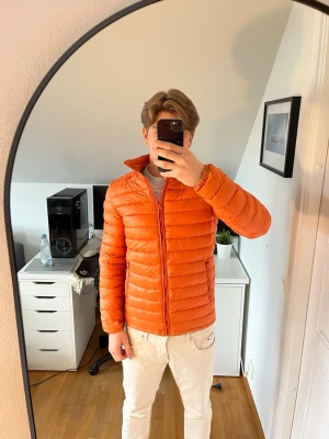 Orange dunjacka från Magasin - Snygg orange dunjacka från Magasin. Jackan har två framfickor och två innerfickor. Hör gärna av dig vid frågor!