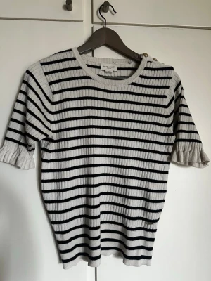 Randig  topp Holly & Whyte Lindex  - Säljer en ribbstickad topp från Holly & Whyte by Lindex i vitt med svarta horisontella ränder. Gullig, basic topp som passar till allt i storlek M