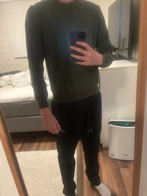 Olivgrön stickad tröja Oscar Jacobson - Snygg olivgrön 100% merinoull tröja från Oscar Jacobson. Tröjan har rund halsringning, långa ärmar och ribbade muddar vid ärmslut och nederkant. Tillverkad i Italien, perfekt för dig som gillar stilrena och klassiska plagg. Storlek S men passar Xs-xxs