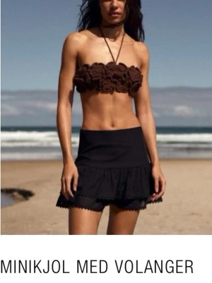 Svart minikjol med volanger från Zara xs  - Supersnygg svart minikjol från Zara med volangkant nedtill. Kjolen har en enkel, stilren design och är perfekt för varma dagar. Tillverkad i ett lätt material som känns skönt mot huden. Passar perfekt till crop tops eller linnen.