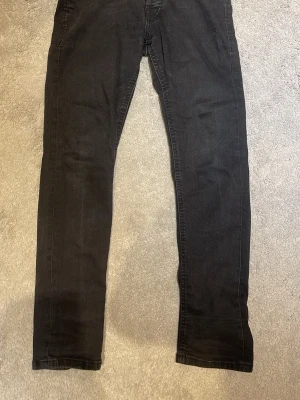  slim fit jeans, slim gelen  - Säljer ett par svarta slim fit jeans med klassisk femficksdesign och dragkedjegylf. Jeansen har smal passform och raka ben, perfekta till en avslappnad stil. Materialet är mjukt och stretchigt för extra komfort.