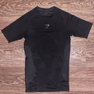 Gymshark baselayer t-shirt - Hej! Jag säljer en svart kompressionströja från Gymshark. Fullständigt namn: Gymshark Element Baselayer T-shirt. Den är inköpt den 16 November 2025 och endast använd ett fåtal gånger, sitter som ny. Storlek S