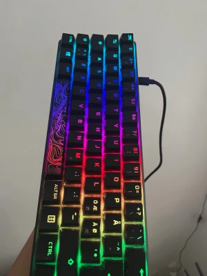 Kompakt mekaniskt tangentbord RGB - Säljer ett kompakt mekaniskt tangentbord med RGB-belysning. Tangentbordet har svart plastchassi och svenska tangenter med specialdesignad tangent på vänster sida. Ansluts via USB och har en snygg regnbågsfärgad bakgrundsbelysning som kan justeras.