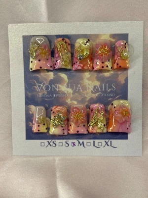 Ibiza (M);Short Duck Nails - Unika handgjorda press-on naglar i mixade färger som rosa, orange och gult med röda/gula prickar. Naglarna har coola 3D-dekorationer i guld som stjärnor, säkerhetsnål och blommor. Formen är short duck nails och i storlek M. Perfekt för dig som vill sticka ut!
