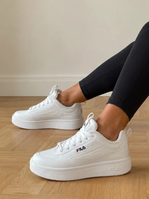 Vita Fila sneakers med chunky sula strl 39 - Snygga vita sneakers från Fila med chunky sula och klassisk logga på sidan och plösen. Skorna har låga skaft, vita snören  Perfekta för en clean och sportig look. Nypris 1000kr