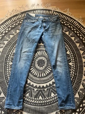 Blå raka jeans från Dondup - Snygga blå jeans från Dondup, modell Bakony, med klassisk femficksdesign och raka ben. Jeansen har slitningar och tvättade detaljer för en avslappnad look. Tillverkade i Italien och har en cool streetkänsla. Storlek: w29
