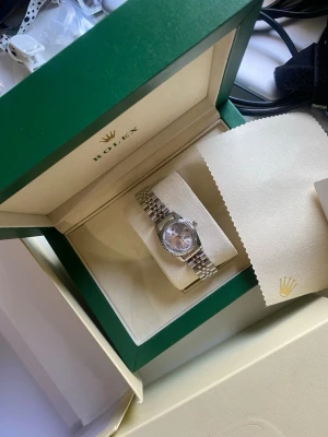 Silverfärgad länkarmbandsklocka - Stilren klocka med silverfärgat länkarmband i rostfritt stål. Klassisk design med rutigt mönster på länken och viklås. Perfekt accessoar för dig som gillar en tidlös look. Utan stora boxen 1200kr en liten box följer med