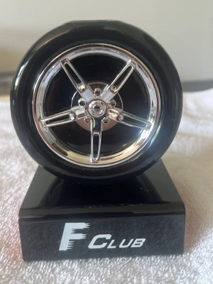 F Club parfym från Tiverton - Unik parfymflaska från Tiverton i modellen F Club, formad som ett svart bildäck med silverfärgad fälg. Flaskan står på en svart bas med logotypen framtill. Perfekt för dig som gillar bilar och vill ha en annorlunda parfymflaska i samlingen. Flaskan rymmer 100ml men mindre än hälften är kvar. Passar till barn/samlare