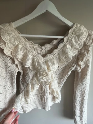 Stickad spetsvolangtröja från Zara - Supersöt stickad tröja från Zara i ljusbeige med v-ringning och långa ärmar. Använd fåtal ggr💖storlek S men passar xs 