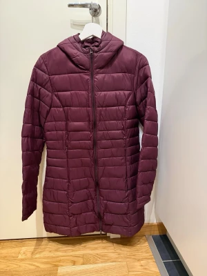 Snygg vinröd pufferjacka med huva. Storlek 38 - Snygg vinröd pufferjacka med huva. Storlek 38  🌺 Säljer en vinröd pufferjacka med huva och dragkedja framtill.  🌺 Jackan har quiltad design och är lite längre i modellen.  🌺 Enkel att matcha med olika outfits. 🌺 Väldigt fint skick, sparsamt använd.  Djur-och rökfritt hem 🌸Se gärna mina andra annonser för samfrakt ✨Har bundle-rabatt