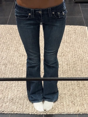  bootcut jeans från True Religion -  bootcut jeans från True Religion med låg midja. Jeansen har ett litet hål på insidan av låret men går lätt att laga om man skulle vilja. De är även utsydda. Men överlag fint skick! Skriv vid frågor eller mått💕