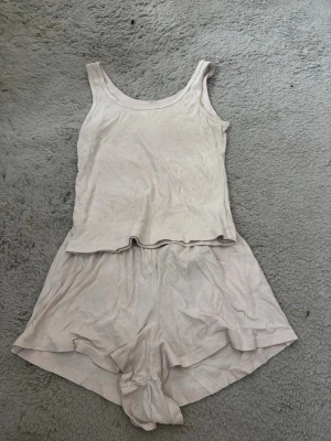 Ljusrosa ribbat loungewear-set linne & shorts - Mysigt loungewear-set i ljusrosa med ribbad struktur. Setet består av ett linne med breda axelband och rund hals samt matchande shorts med lös passform. Perfekt för chill dagar hemma. Materialet känns mjukt och stretchigt.