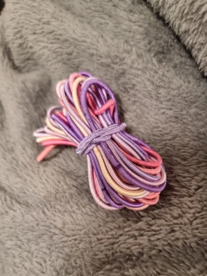 Flerfärgade hårsnoddar i pastell - Säljer ett set med elastiska hårsnoddar i lila, rosa, och lavendel. Perfekta för att fixa snygga frisyrer eller bara ha som färgglad detalj i håret. Tillverkade i mjukt och stretchigt material.